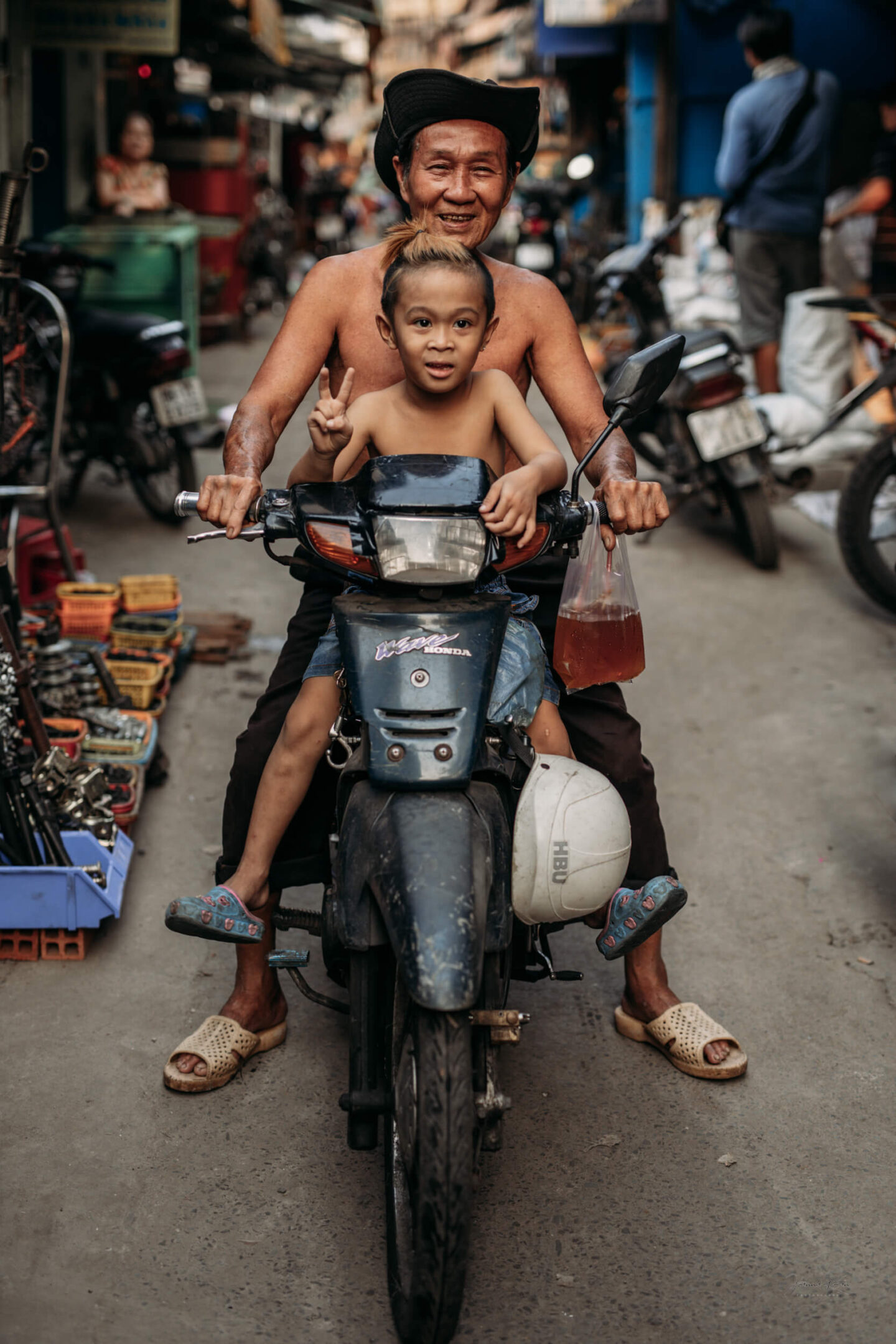 A man with a child ride a motorbike through a local market in Ho Chi Minh city, Southeast Vietnam.